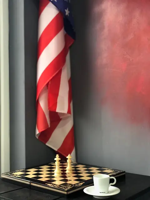 Tablă de șah, cafea și steag american în zona de așteptare