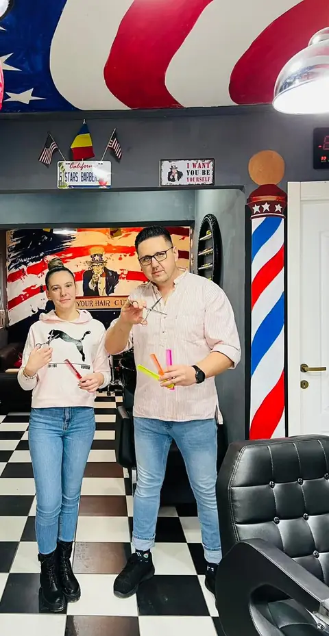 Frizerul Five Stars alături de o colegă, lângă barber pole