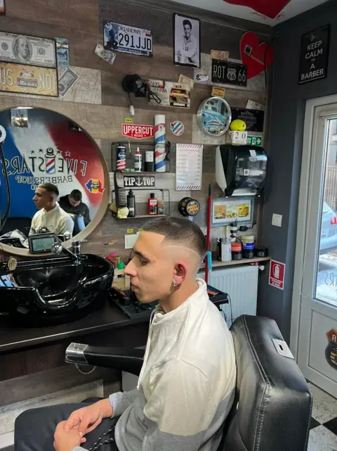 Client cu buzz cut privind în oglinda rotundă