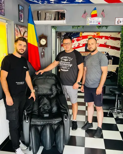 Frizerii Five Stars cu un client, lângă scaunul de masaj