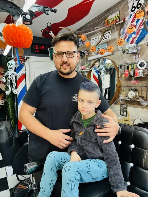 Frizerul Five Stars cu un băiețel după tuns
