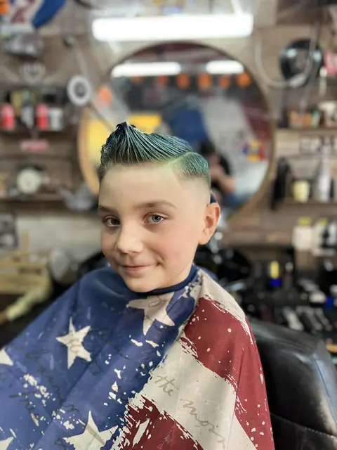 Băiat cu fade și creastă verde, pelerină cu steag american