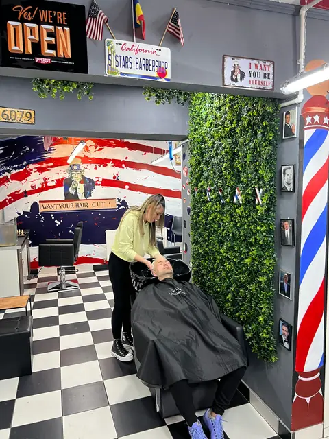 Clientă la spălat păr, sub muralul „I want your hair cut”