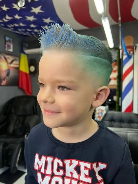Băiat cu creastă albastră și fade verde, zâmbind
