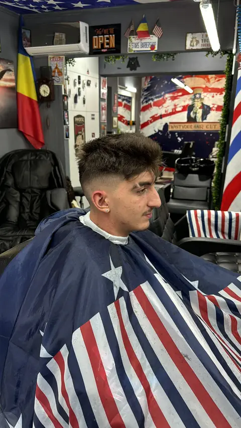 Tânăr cu fade și creștet texturat, sub pelerina americană