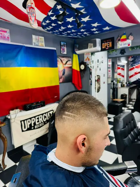 Bărbat cu buzz cut și linii desenate pe lateral