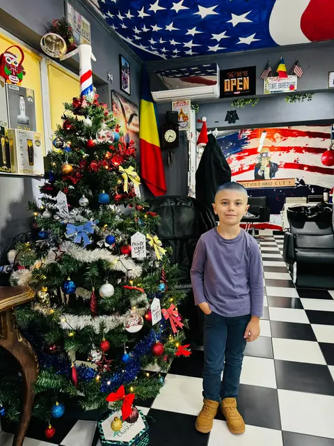 Băiețel lângă bradul de Crăciun din salon