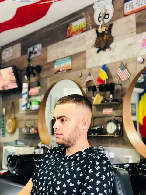 Bărbat cu fade scurt și contur curat, din profil