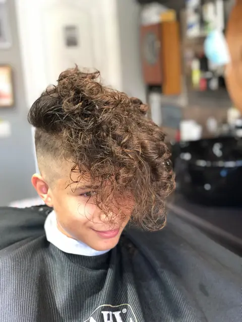 Adolescent cu bucle lungi pe creștet și laterale tunse scurt