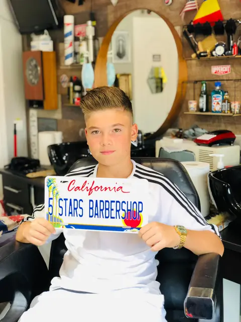 Adolescent cu tunsoare laterală, cu plăcuța California Five Stars