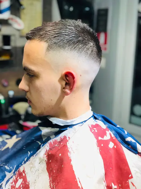 Bărbat cu skin fade și creștet scurt, din profil