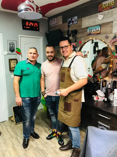 Frizerul Five Stars cu șorț, alături de doi clienți