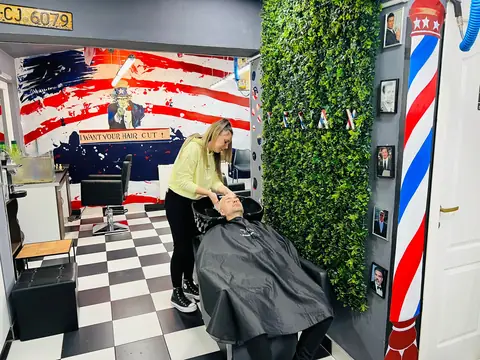 Clientă la spălat păr în salonul Five Stars, cu steagul american pictat pe perete